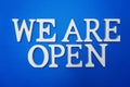 We are Open alphabet letters on blue background