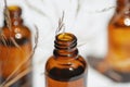 Open amber bottle with serum or essential oil with wild field grass.