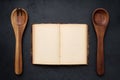 Open antique cookbook with blank pages and two wooden spoons, top view, layout Royalty Free Stock Photo