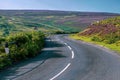 Open asphalt roadway winding through a grassy hillside landscape, Pennines moorland Royalty Free Stock Photo