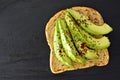 Open avocado sandwich with chia seeds on dark slate