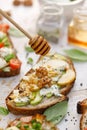 Open avocado sandwich made of slice of sourdough bread with the addition of pear, blue cheese, nuts and honey, close-up. Royalty Free Stock Photo