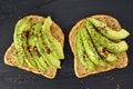 Open avocado sandwiches with chia seeds on dark slate