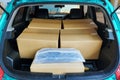 Open back door hatchback view many parcel boxes in car Royalty Free Stock Photo