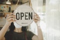 Open. barista, waitress woman wearing protection face mask turning open sign board on glass door in modern cafe coffee shop Royalty Free Stock Photo