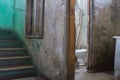 Worn bathroom near a decayed staircase in condemned building. Royalty Free Stock Photo