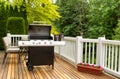 Open BBQ cooker and bottled beer on outdoor cedar patio Royalty Free Stock Photo