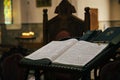 The open Bible in armenian language lying in the empty dark Armenian Church