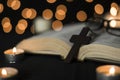 Open bible book with cross and candle lights against bokeh lights background Royalty Free Stock Photo