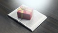 Open Bible. Book. Gift in a red package with a gold bow. On a wooden table. Royalty Free Stock Photo