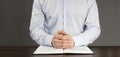 Open Bible book on the table. Prayer. White cup. Young man in shirt prays with folded hands. Royalty Free Stock Photo