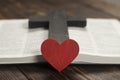 Open Bible book on a wooden table. Wooden cross of Jesus. Red heart. The concept of loving God`s Word Royalty Free Stock Photo