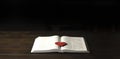 Open Bible book on a wooden table. Red heart. The concept of love for God`s Word. Royalty Free Stock Photo