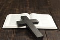 Open Bible book on a wooden table. Wooden cross of Jesus. The concept of love for God`s Word. Royalty Free Stock Photo