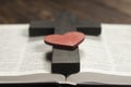 Open Bible book on a wooden table. Wooden cross of Jesus. Red heart. The concept of loving God`s Word Royalty Free Stock Photo