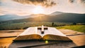 Open bible book on a wooden table at sunset with cross in front of it. Strong Christian faith Royalty Free Stock Photo