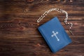 Open bible, candle, christian cross and human hands on wooden background. Prayer to God Royalty Free Stock Photo