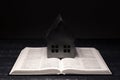 Open Bible. Miniature house. Prayer. On a wooden table. Holy book, Scripture. Royalty Free Stock Photo