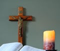 Open Bible with crucifix and lit candle Royalty Free Stock Photo