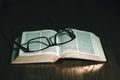 Open Bible with glasses on top Royalty Free Stock Photo