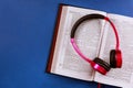 Open Bible on a headphones on religious audiobook