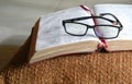 Open bible on a pilllow, with reading glasses on top of it Royalty Free Stock Photo