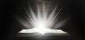 Open Bible. Rays of light come down from the book. The Holy Book. On a wooden table