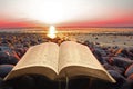 Open bible spiritual light on seashore