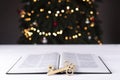 An open Bible on the table. The key is on the book. Know the symbol. On the background of the Christmas tree.