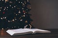 An open Bible on the table. Prayer. Christmas background. Candles, lights and garlands Royalty Free Stock Photo