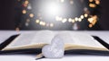 An open Bible on the table. Prayer. Scripture. God is love. Heart. On the background of the Christmas tree. Royalty Free Stock Photo