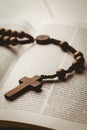 Open bible and wooden rosary beads Royalty Free Stock Photo