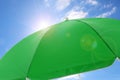 Open big green beach umbrella and beautiful blue sky with white clouds on background Royalty Free Stock Photo