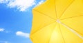 Open big yellow beach umbrella and beautiful blue sky with white clouds on background Royalty Free Stock Photo