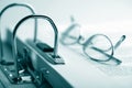 Open binder and glasses over document Royalty Free Stock Photo