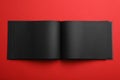 Open black notebook on red background Royalty Free Stock Photo