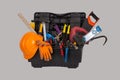 An open black plastic tool kit box with an construction orange protective helmet and various hand tools isolated on a grey backgro Royalty Free Stock Photo