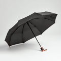 Open black umbrella on plain light surface Royalty Free Stock Photo