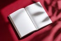 Open blank book, notebook lies on burgundy red surface. Soft shadows of leaves create a pattern across empty pages. Top view Royalty Free Stock Photo