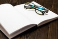 Open blank book, pen and glasses on dark wooden table. View from above. Space for text. Free space for text Royalty Free Stock Photo
