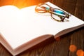 Open blank book, pen and glasses on dark wooden table. View from above. Space for text. Toned sunlight. business concept Royalty Free Stock Photo