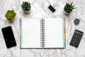 Open blank note book, glasses, cup of coffee, pen, smartphone, succulents on marble table Royalty Free Stock Photo