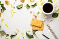 An open blank notebook and a black pencil, cup of coffee and cookies on a white wooden background among dry leaves and flower Royalty Free Stock Photo