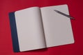 Open blank notebook with blue cover on red backgroun