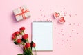 Open blank notebook with gift box, flowers and hearts on a pink background. Valentines day background. Royalty Free Stock Photo