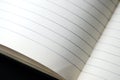 Open blank notebook with lined pages on a dark background close-up. Educational or business concept Royalty Free Stock Photo