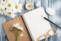 Open blank notebook, pebbles, flowers