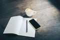 Open blank notebook, pen, cell phone and cup of coffee on wooden Royalty Free Stock Photo