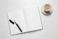 Open blank notebook, pen and coffee on white wooden table, flat lay Royalty Free Stock Photo