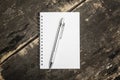 Open blank notebook with silver pencil on grunge wood backgroun